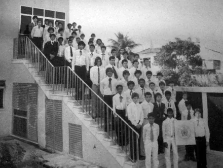 Foto histórica em preto e branco de jovens enfileirados na escadaria de uma sede, nos primeiros anos da Ordem no Brasil