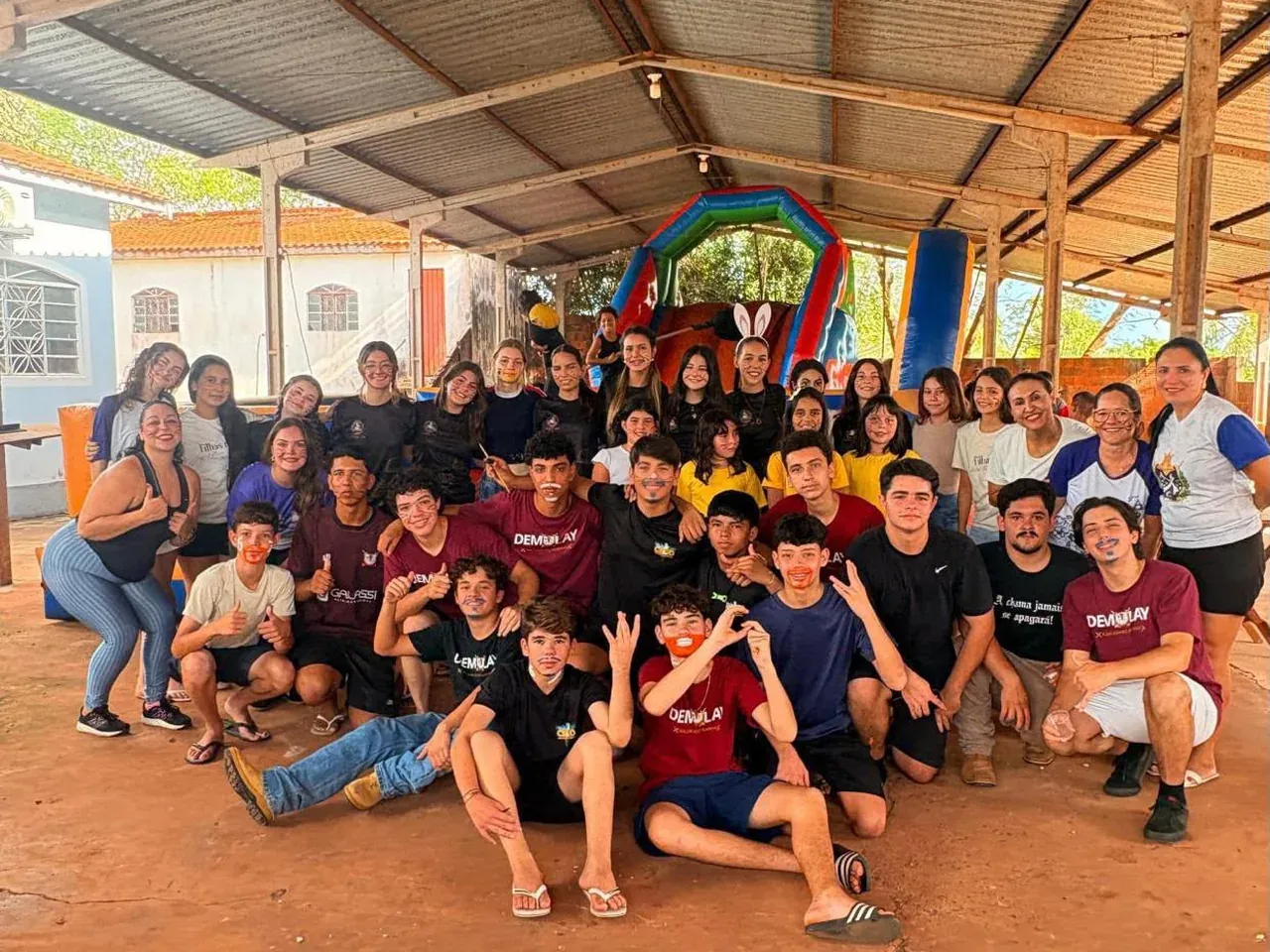 Jovens e famílias reunidos sob um galpão em uma ação social do Desafio Nacional de Filantropia